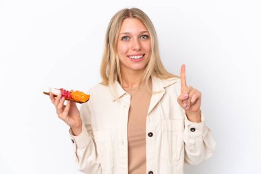 Beyaz arka planda saşimi tutan beyaz bir kadın en iyinin işareti olarak parmağını kaldırıyor.