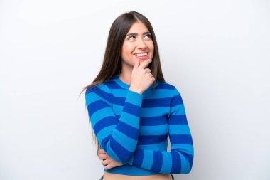 Beyaz arka planda izole edilmiş genç beyaz kadın yan bakıyor ve gülümsüyor.