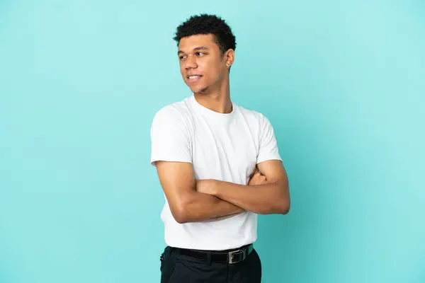 stock image Young African American man isolated on blue background looking to the side and smiling
