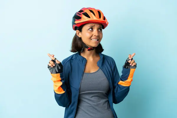 Jeune Cycliste Femme Isolée Sur Fond Bleu Avec Les Doigts Photo De Stock