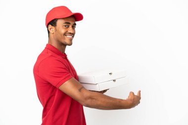 Afrikalı Amerikalı pizzacı izole edilmiş beyaz duvarın üzerinden pizza kutuları alıyor.