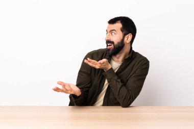 Masada sakallı, beyaz bir adam. Taraf tutarken yüzünde sürpriz bir ifade var..