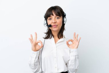 Tele pazarlamacı, beyaz arka planda izole edilmiş kulaklıkla çalışan melez bir kadın parmaklarıyla 