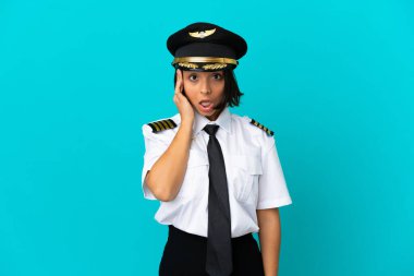 İzole edilmiş mavi arka plan üzerinde genç bir uçak pilotu bir şey fark etti ve çözümü amaçlıyor.