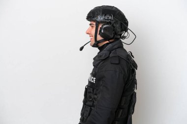 SWAT caucasian man isolated on white background laughing in lateral position