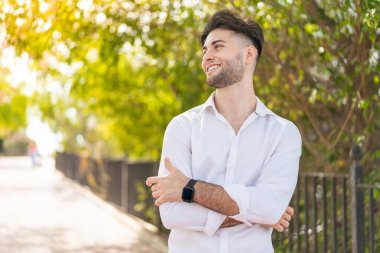 Dışarıdaki yakışıklı adam mutlu ve gülümsüyor.