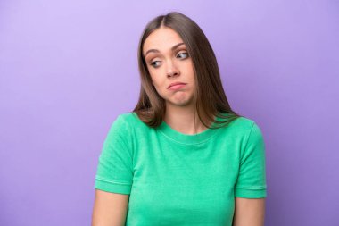 Mor arka planda izole edilmiş genç beyaz kadın şüpheli hareketler yapıyor.