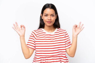 Genç Kolombiyalı kadın Zen pozunda beyaz arka planda izole edilmiş.