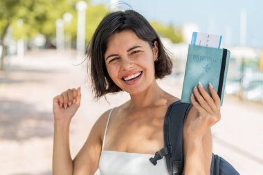 Açık havada elinde pasaport tutan ve zaferi kutlayan genç, güzel Bulgar kadın.