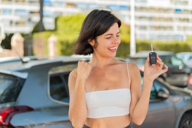 Genç ve güzel Bulgar kadın açık havada zaferi kutlarken arabanın anahtarlarını tutuyor