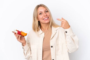 Beyaz arka planda saşimi tutan beyaz saçlı genç bir kadın baş parmak işareti yapıyor.