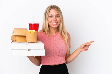 Mavi arka planda izole edilmiş yağlı yiyecekler tutan beyaz bir kadın var.