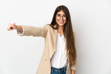 Beyaz arka planda izole edilmiş genç beyaz bir kadın baş parmak hareketi yapıyor.