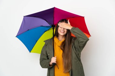 Beyaz arka planda izole edilmiş bir şemsiye tutan genç bir kadın gözlerini elleriyle kapatıyor. Bir şey görmek istemiyorum.