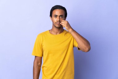 Örgülü genç Afrikalı Amerikalı adam mor arka planda izole edilmiş sessizlik işareti gösteriyor.