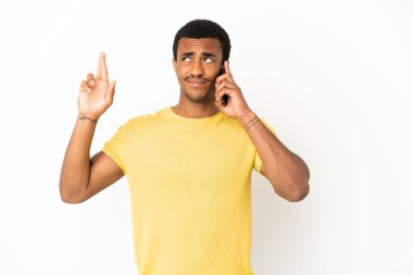 Afro-Amerikalı yakışıklı adam izole edilmiş beyaz arka planda cep telefonu kullanıyor.