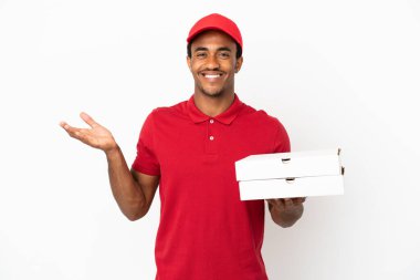 Afro-Amerikalı pizza teslimatçısı izole edilmiş beyaz duvarın üzerinden pizza kutuları alıyor.