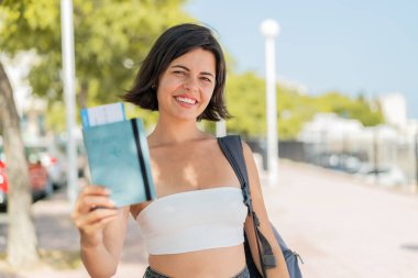 Genç ve güzel Bulgar kadın elinde neşeli bir ifadeyle dışarıda bir pasaport tutuyor.