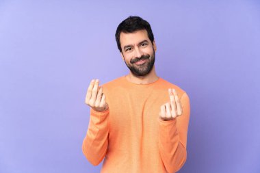 Kafkasyalı yakışıklı adam soyutlanmış mor arka planda para hareketi yapıyor.