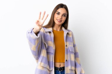 Mor arka planda izole edilmiş beyaz kadın mutlu ve parmaklarıyla üçe kadar sayıyor.