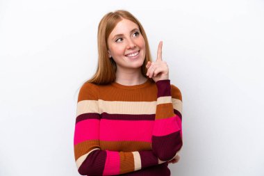 Beyaz arka planda izole edilmiş genç kızıl kadın harika bir fikre işaret ediyor.