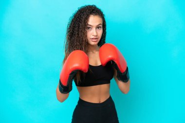 Genç Arap kadın mavi arka planda boks eldivenleriyle izole edilmiş.