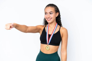 Beyaz arka planda madalyaları olan genç bir bayan baş parmak hareketi yapıyor.