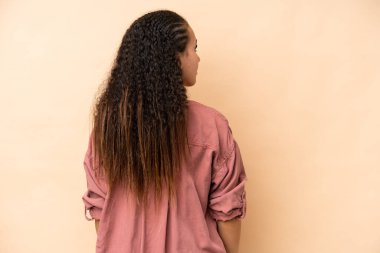 Bej arka planda izole edilmiş genç bir kadın.