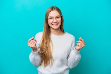 Mavi arka planda izole edilmiş genç bir Rus kadın para hareketi yapıyor.