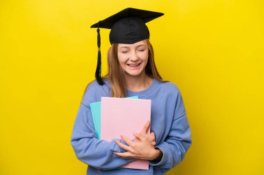 Sarı arka planda izole edilmiş genç Rus kadın çok fazla gülümsüyor.