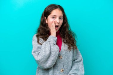 Küçük kız mavi arka planda mahsur kalmış, şaşırmış ve şok olmuş bir yüz ifadesi var.