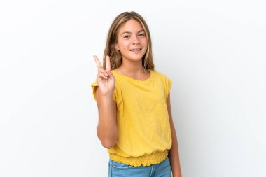 Beyaz arka planda izole edilmiş küçük beyaz kız gülümsüyor ve zafer işareti gösteriyor.