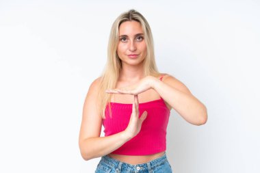 Beyaz arka planda izole edilmiş genç beyaz bir kadın zaman aşımı hareketi yapıyor.