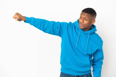 Beyaz arka planda izole edilmiş genç latin adam baş parmak işareti yapıyor.