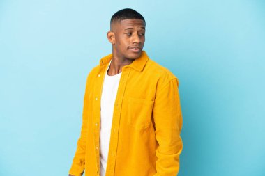 Genç latin adam mavi arka planda izole edilmiş. Portre