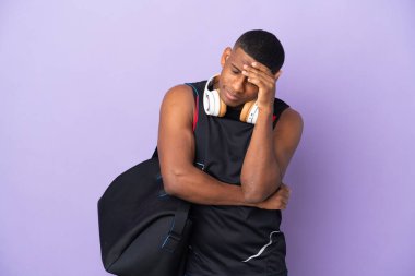 Spor çantalı genç Latin bir adam mor arka planda baş ağrısı ile izole edilmiş.