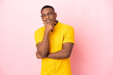 Genç Latin adam pembe arka planda izole edilmiş gülümsüyor.