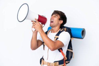 Genç dağcı kadın, izole edilmiş beyaz arka planı olan büyük bir sırt çantasıyla megafonla bağırıyor.