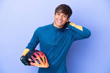 Mor arka planda izole edilmiş genç beyaz adam gülüyor.