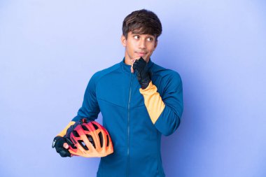 Mor arka planda izole edilmiş genç beyaz bir adamın şüpheleri ve düşünceleri var.