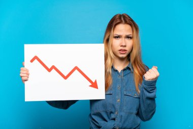 İzole edilmiş mavi arka plan üzerinde genç bir kız elinde azalan bir istatistik oku sembolü ve kızgın bir tabela tutuyor.