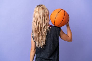 Mor arka planda izole edilmiş, basketbol oynayan genç bir Rus kadın.