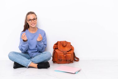 Genç bir öğrenci beyaz arka planda tek başına oturmuş para hareketi yapıyor.