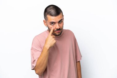 Beyaz arka planda izole edilmiş genç beyaz adam bir şey gösteriyor.