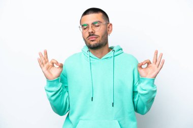 Beyaz arka planda Zen pozisyonunda beyaz tenli genç bir adam