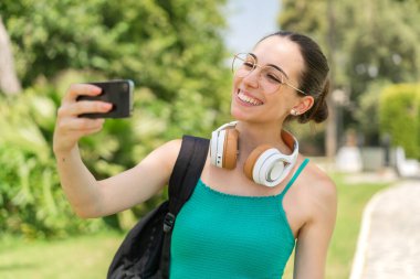 Açık havada selfie çeken güzel bir kadın.