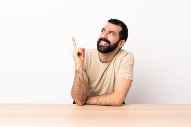 Masada sakallı beyaz bir adam harika bir fikri işaret ediyor..