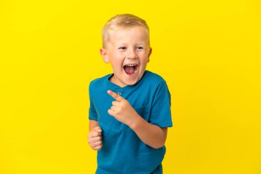 Sarı arka planda izole edilmiş küçük Rus çocuk parmağını kaldırarak çözümü bulmaya çalışıyordu.