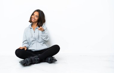 Paten kayan genç Asyalı kadın mutlu bir ifadeyle ön tarafı işaret ediyor.