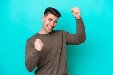 Mavi arka planda izole edilmiş beyaz bir adam zaferi kutluyor.